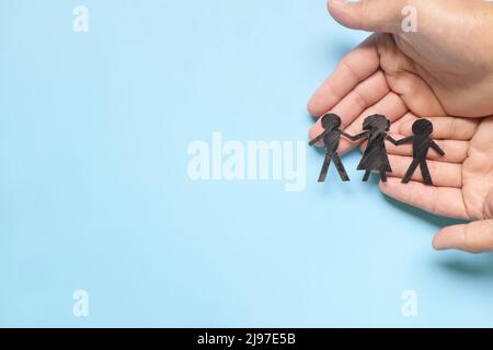 Main tenant les enfants découpe de papier. Notion : réadaptation, garde, droits de l'homme et protection des réfugiés. Banque D'Images