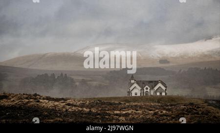 un grand cliché d'un ancien terrain brûlé et d'une grande maison d'époque et d'une chaîne de montagnes en toile de fond par une journée brumeuse Banque D'Images