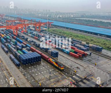 Chongqing, Chine. 21st mai 2022. (220521) -- CHONGQING, le 21 mai 2022 (Xinhua) -- photo aérienne prise le 21 mai 2022 montre un train de marchandises Chine-Laos qui attend de partir dans une gare dans la municipalité de Chongqing, dans le sud-ouest de la Chine. Samedi, un train de marchandises transportant des produits alimentaires et des machines agricoles locaux a quitté une gare dans la municipalité de Chongqing, dans le sud-ouest de la Chine, pour rejoindre Vientiane, la capitale du Laos, marquant le lancement du premier train de marchandises Chine-Laos qui bénéficie d'un canal d'entrée et d'exportation rapide favorable. Le canal d'entrée et d'exportation rapide permet d'économiser 24 heures dans le processus de dédouanement, ce qui permet de raccourcir les temps Banque D'Images