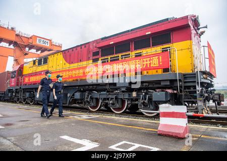 Chongqing, Chine. 21st mai 2022. (220521) -- CHONGQING, le 21 mai 2022 (Xinhua) -- des agents des douanes inspectent un train de marchandises Chine-Laos avant son départ dans la municipalité de Chongqing, dans le sud-ouest de la Chine, le 21 mai 2022. Samedi, un train de marchandises transportant des produits alimentaires et des machines agricoles locaux a quitté une gare dans la municipalité de Chongqing, dans le sud-ouest de la Chine, pour rejoindre Vientiane, la capitale du Laos, marquant le lancement du premier train de marchandises Chine-Laos qui bénéficie d'un canal d'entrée et d'exportation rapide favorable. Le canal d'entrée et d'exportation rapide permet d'économiser 24 heures dans le processus de dédouanement, ce qui permet de raccourcir le trajet Banque D'Images