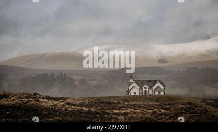 un grand cliché d'un ancien terrain brûlé et d'une grande maison d'époque et d'une chaîne de montagnes en toile de fond par une journée brumeuse Banque D'Images