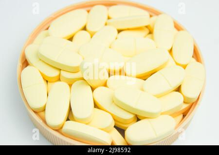 Une pile de comprimés de calcium et de vitamine D complémentaires isolés sur fond blanc Banque D'Images