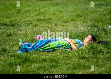 Londres, Royaume-Uni, 21 mai 2022. Une femme se bronzer au printemps après-midi soleil sur Wimbledon Common, sud-ouest de Londres avec des conciles chaudes et des températures élevées prévues pour la semaine prochaine.Credit. amer ghazzal/Alamy Live News Banque D'Images