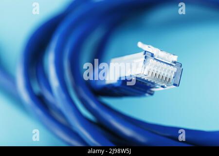 Une bobine de câble réseau Internet Ethernet RJ45 de catégorie 6 isolée sur fond bleu avec de l'espace libre Banque D'Images