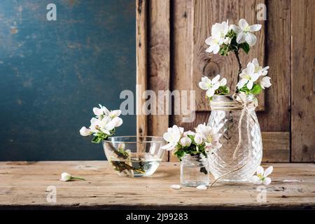 Fleur de pomme dans un bol en verre sur fond de bois. Banque D'Images