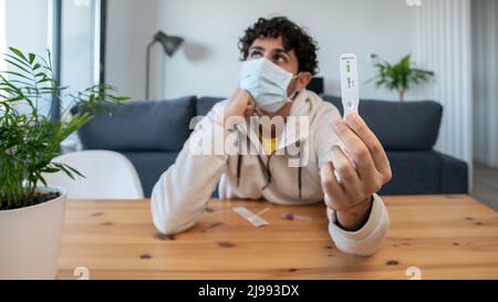 L'homme caucasien fabrique un appareil de test rapide à domicile pour le virus Covid19 avec un résultat négatif. Cassette d'antigène de test PCR express pour la nouvelle variante d'Omicron vi Banque D'Images