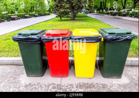 Conteneurs en plastique multicolore pour la collecte séparée des déchets dans le parc de la ville. Séparez les poubelles en fonction du type de déchets Banque D'Images