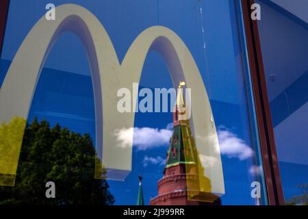 Moscou, Russie. 21st mai 2022. Une tour du Kremlin se reflète dans la fenêtre d'un restaurant McDonald's fermé sur la place Manezhnaya dans le centre de Moscou, en Russie. Le 16 mai 2022, la chaîne de restauration rapide américaine a annoncé son intention de se retirer de la Russie et a lancé un processus de vente de ses activités russes Banque D'Images