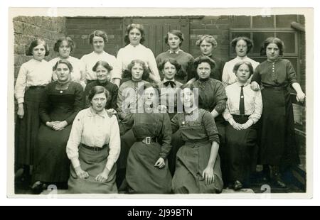 Original et clair WW1 ans groupe en plein air portrait de filles de moulin de textile à argiles Mill. Ils sont soit des opérateurs de l'usine portant leur dimanche meilleur ou le personnel de bureau. Beaucoup de chemisiers et de vêtements de jupe différents de l'époque. Trois des filles portent des badges, peut-être ceux de la compagnie "sur le service de guerre". Les filles travaillent dans la fabrication - peut-être des lainages ou des textiles de coton. Clay's Mill, Halifax, Yorkshire, Angleterre, Royaume-Uni vers 1915 ,1916 Banque D'Images