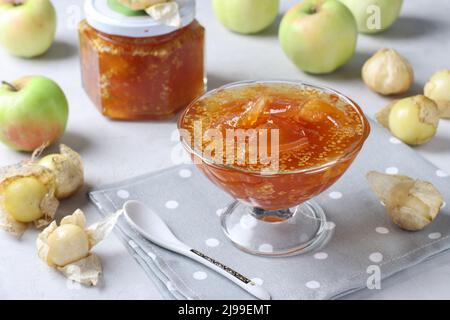 Confiture physalis et pommes faites maison dans un bol et un bol en verre sur fond gris clair Banque D'Images