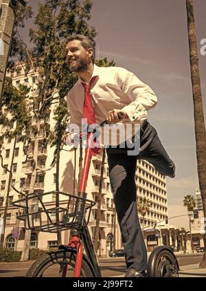 Le démarrage en ligne est amusant.Joyeux réalisateur s'amuse à faire des pirieurs le long du trottoir.Scooter électrique debout Banque D'Images