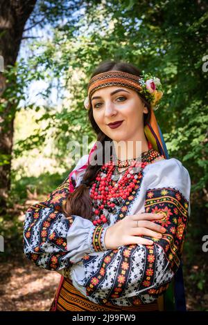 Fille ukrainienne dans la robe nationale ukrainienne se tient sur un chemin dans les bois. Banque D'Images