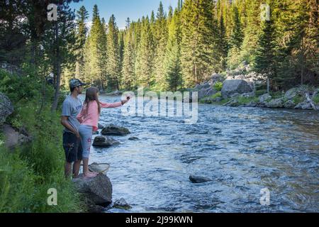 Un père aide ses enfants à pêcher la truite sur la fourche Henry's de la rivière Snake, Island Park, Fremont County, Idaho, États-Unis Banque D'Images