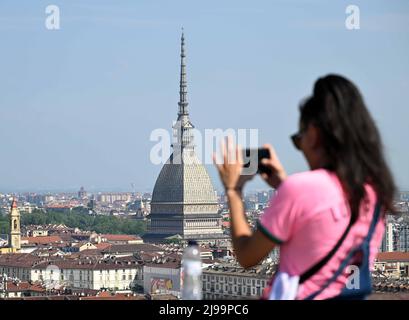 Turin, Italie. 21st mai 2022. Un touriste prend des photos près de la Mole Antonelliana à Turin, Italie, le 21 mai 2022. De nombreuses régions à travers l'Italie, y compris Turin, ont atteint 30 degrés centigrades samedi. Crédit: Alberto Lingria/Xinhua/Alay Live News Banque D'Images