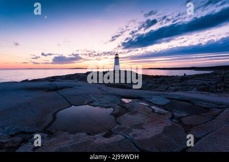 Peggy's Cove Lighthouse pendant un coucher de soleil vibrant. Côte Atlantique, Nouvelle-Écosse, Canada. L'endroit touristique le plus visité au Canada atlantique Banque D'Images