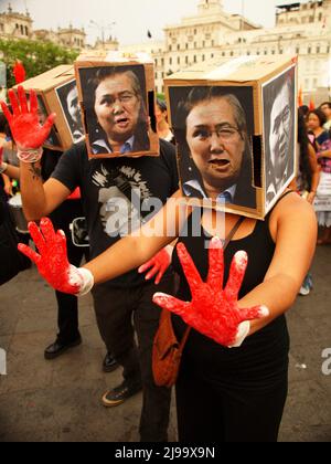 Des centaines d'activistes, costumés comme Alberto Fujimori montrant leurs mains sanglantes, ont pris par force la place principale de Lima, à l'occasion de l'anniversaire du coup d'État d'Alberto Fujimori. Les manifestants ont exigé la non-oubli et aucune impunité pour les responsables des milliers de disparus, les stérilisations forcées, la corruption et la réduction des libertés civiles pendant le gouvernement Fujimori. Banque D'Images