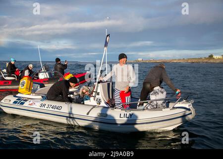 (220522) -- LE CAP, 22 mai 2022 (Xinhua) -- l'homme sud-africain Howard Warrington (2nd R) se prépare à nager dans la mer de l'île Robben à la rive du Cap, en Afrique du Sud, le 21 mai 2022. L'homme sud-africain Howard Warrington a achevé samedi matin son passage en mer de 100th de la célèbre île Robben à la rive du Cap, pour recueillir des fonds pour Cape of Good Hope SPCA (Société pour la prévention de la cruauté envers les animaux), une organisation de protection des animaux. (Photo de Francisco Scarbar/Xinhua) Banque D'Images