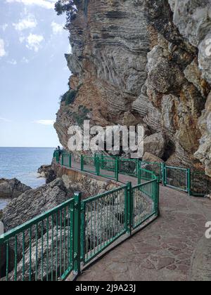 Sentier avec clôture près de la mer et du rocher à la plage de Mogren à Budva, Monténégro Banque D'Images