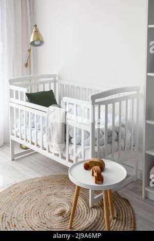 Intérieur de la chambre de bébé avec lit de bébé, lampe et table Banque D'Images