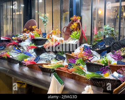 Paris, France - 7 avril 2022 : poisson frais dans des corbeilles à glace joliment décorées. Un marché aux poissons dans un quartier commerçant de Paris. Banque D'Images