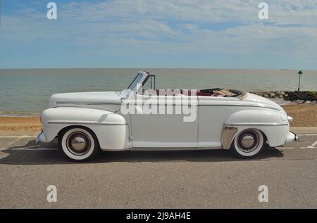 Voiture convertible Super Delux Ford blanc classique en vue sur le front de mer. Banque D'Images