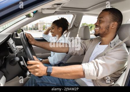 Les conjoints joyeux conduisent une voiture lors de vacances d'été Banque D'Images