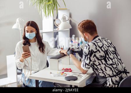 Femme client obtenant traitement manucure procédure dans le salon Banque D'Images