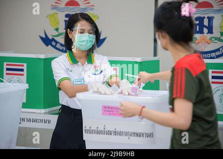 Un responsable du scrutin voit porter un masque de visage et un écran facial lors de l'élection du nouveau gouverneur de Bangkok dans un bureau de vote. Élection du nouveau gouverneur de Bangkok à Bangkok. Ce sera la première de ces élections dans neuf ans depuis 2013, après que l'armée a pris le pouvoir lors du coup d'État de 2014. Banque D'Images