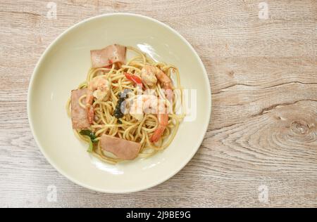 crevettes spaghetti sautées épicées avec tranche de porc au jambon et feuille de basilic sur l'assiette Banque D'Images