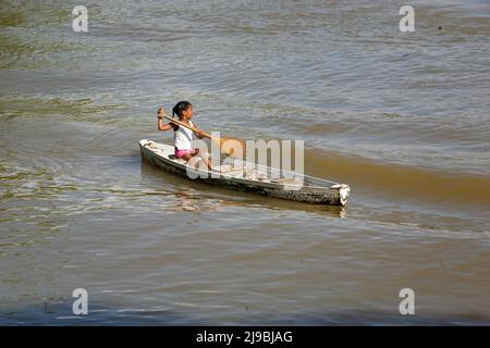 Jeune fille à bord d'un canot en bois seul dans le fleuve Guamá, une partie du fleuve Amazone, près de Belém, Pará, Amazone, Brésil. Janvier 2008. Banque D'Images