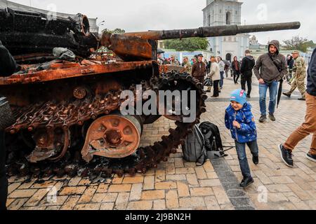 KIEV, KIEV, Ukraine. 22nd mai 2022. Un gamin court devant l'épave d'un char russe exposé à Kiev pour la vitrine de la résistance ukrainienne, au milieu de l'invasion russe. Les forces russes avançant leurs attaques contre Kharkiv et Donbass, les États-Unis ont approuvé une nouvelle série de militaires en soutien aux forces ukrainiennes. (Image de crédit : © Daniel Cing Shou-Yi/ZUMA Press Wire) Banque D'Images