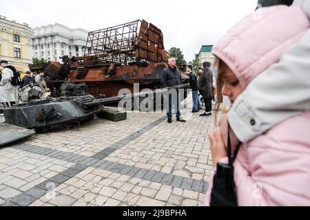 KIEV, KIEV, Ukraine. 22nd mai 2022. Les parents et leurs enfants arpentent les épaves des chars russes et des véhicules blindés exposés à Kiev pour la vitrine de la résistance ukrainienne, dans le cadre de l'invasion russe. Les forces russes avançant leurs attaques contre Kharkiv et Donbass, les États-Unis ont approuvé une nouvelle série de militaires en soutien aux forces ukrainiennes. (Image de crédit : © Daniel Cing Shou-Yi/ZUMA Press Wire) Banque D'Images