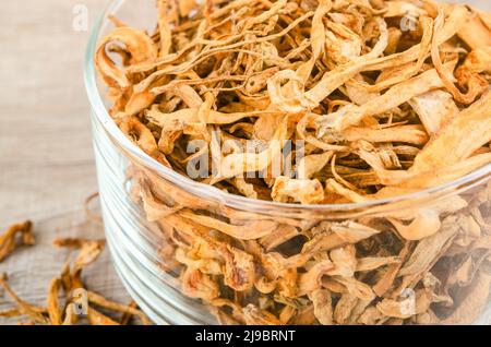 Le cordyceps militaris séché fleur de champignon sur fond de bois. Banque D'Images