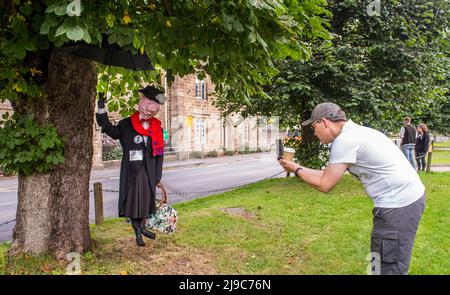 Un visiteur prend une photo d'une arnaque de Mary Poppins lors du festival annuel Scarecrow Pigfest à Ripley, près de Harrogate en Angleterre. Banque D'Images