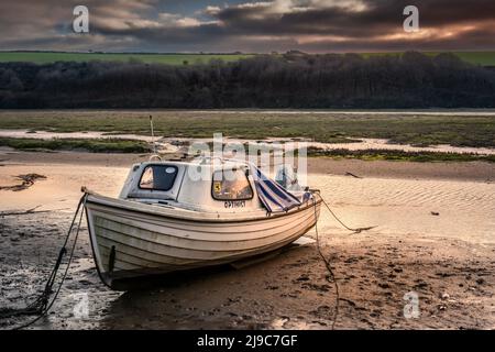 Un petit bateau à moteur amarré sur la rive boueuse de la rivière Gannel à Newquay, en Cornouailles. Banque D'Images