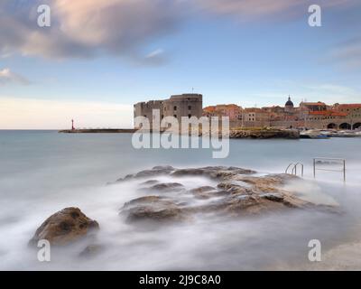 Vagues se lavant sur des rochers en face du vieux port de Dubrovnik. Banque D'Images