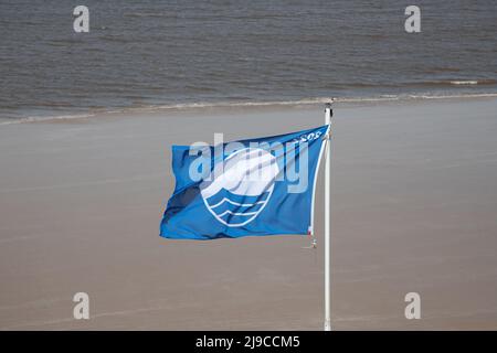 Prestigieux drapeau bleu volant sur Sheringham Beach à North Nofolk, Royaume-Uni, lors d'une journée de printemps venteuse Banque D'Images