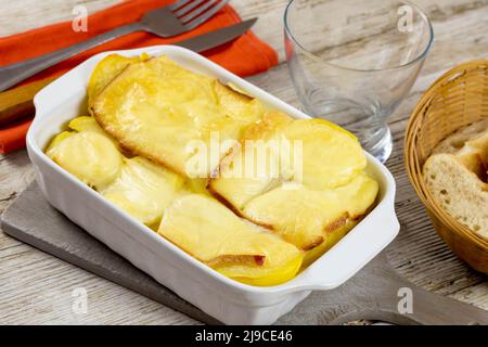 pomme de terre avec raclette sur table en bois Banque D'Images