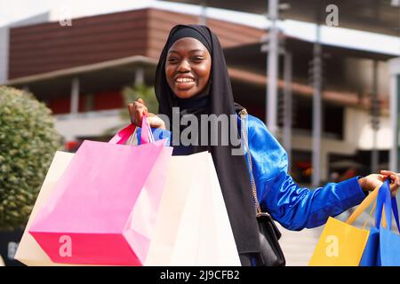 Joyeux shopper musulman avec des sacs en papier Banque D'Images