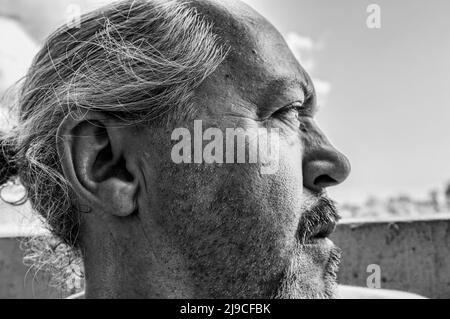 portrait de profil noir et blanc d'un homme sérieux avec barbe et cheveux grisants recueillis Banque D'Images