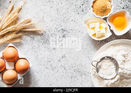 Cadre de cuisson ou de cuisson. Ingrédients, articles de cuisine pour cuire des gâteaux. Ustensiles de cuisine, farine, œufs, cassonade, beurre. Espace texte, haut v Banque D'Images