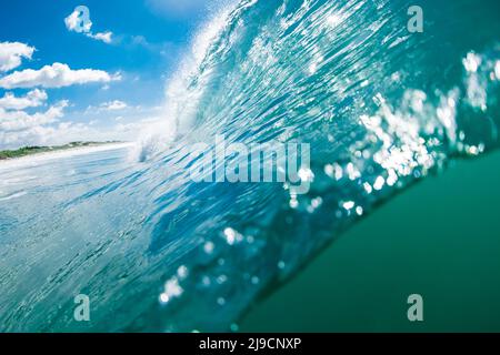Vue rapprochée de la vague turquoise dans l'océan. Vague de tonneau avec soleil Banque D'Images