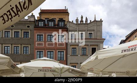 VARSOVIE, POLOGNE - 14 MAI 2022 : vue sur le bâtiment autour de la place du marché de la vieille ville à travers des parasols de restaurant Banque D'Images