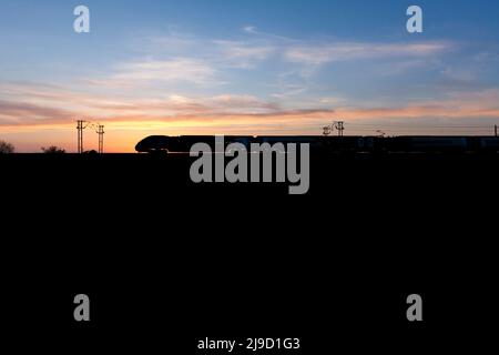 Avanti West Coast classe 390 Alstom silhouette Pendolino sur la ligne principale de la côte ouest au coucher du soleil Banque D'Images