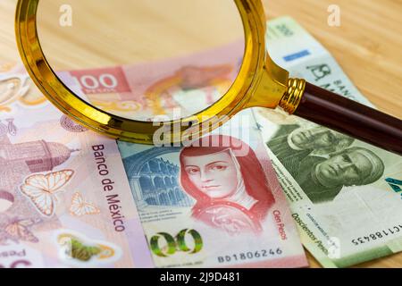 Argent mexicain, billets étalées sur la table, loupe couchée, concept financier de l'entreprise de budget domestique Banque D'Images