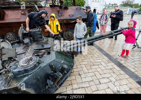 Kiev, Ukraine. 22nd mai 2022. Des enfants et des adultes ukrainiens font une enquête sur l'épave d'un baril de véhicule blindé russe exposé pour mettre en valeur la résistance ukrainienne, dans le cadre de l'invasion russe. Les forces russes avançant leurs attaques contre Kharkiv et Donbass, les États-Unis ont approuvé une nouvelle série de militaires en soutien aux forces ukrainiennes. (Image de crédit : © Daniel Cing Shou-Yi/ZUMA Press Wire) Banque D'Images