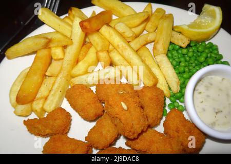 Une vue savoureuse sur les frites et les petits pois de Crispy Cod Bites Banque D'Images