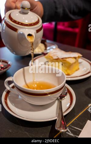 Temps du thé en Angleterre, verser du thé noir earl Grey avec bergamote dans une tasse, thé dînatoire servi café à Londres, gros plan Banque D'Images