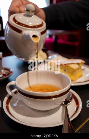 Temps du thé en Angleterre, verser du thé noir earl Grey avec bergamote dans une tasse, thé dînatoire servi café à Londres, gros plan Banque D'Images