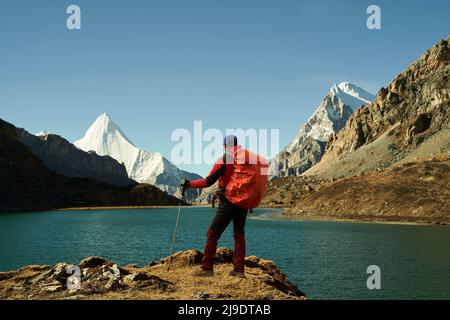 trekker asiatique debout près du lac boyongcuo regardant le mont jampayang (ou yangmaiyong) dans le parc national de yading, comté de daocheng, province du sichuan, chine Banque D'Images